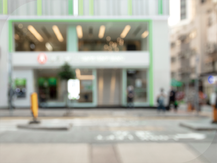 Young couple walking in front of a branch of Hang Seng Bank